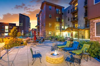 A patio with chairs and a fire pit in the middle of a city.